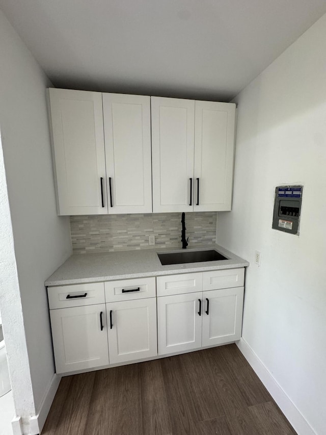 bar with backsplash, sink, and white cabinets