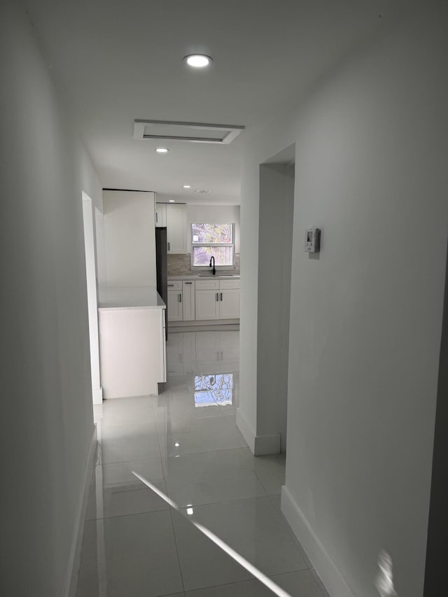 corridor with sink and light tile patterned floors