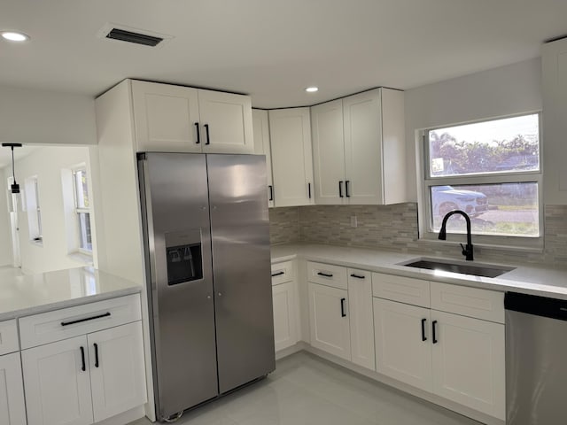 kitchen with white cabinetry, appliances with stainless steel finishes, sink, and tasteful backsplash