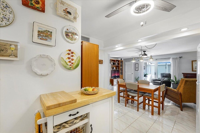 tiled dining space featuring ceiling fan