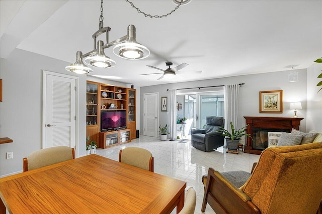 dining area featuring a multi sided fireplace and ceiling fan