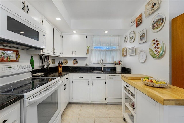 kitchen featuring sink, white appliances, light tile patterned floors, and white cabinets