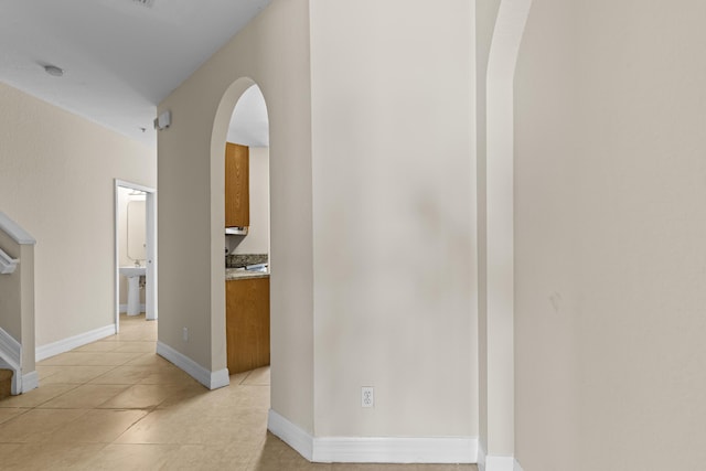 hall featuring sink and light tile patterned floors