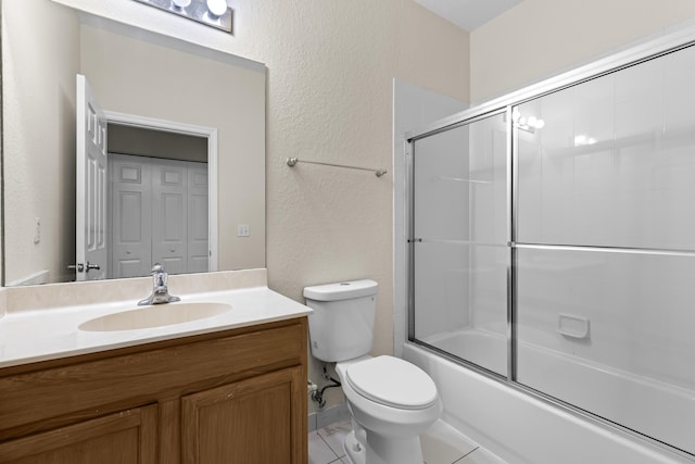 full bathroom with vanity, bath / shower combo with glass door, and toilet