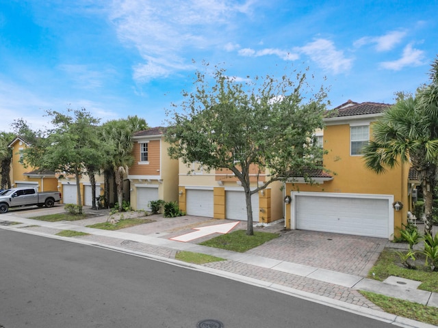 773 Pipers Cay Dr, West Palm Beach, FL 33415 - townhome / multi-family property with a garage, stucco siding, decorative driveway, and a tiled roof