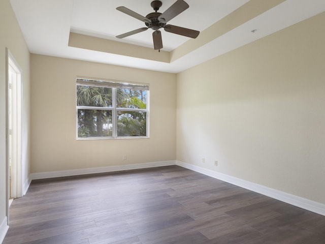 773 Pipers Cay Dr, West Palm Beach, FL 33415 - empty room featuring a raised ceiling, dark wood-style flooring, ceiling fan, and baseboards