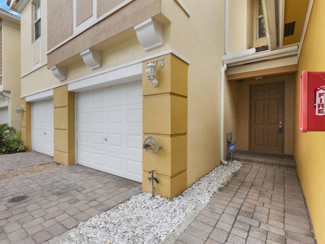 773 Pipers Cay Dr, West Palm Beach, FL 33415 - doorway to property with a garage and stucco siding