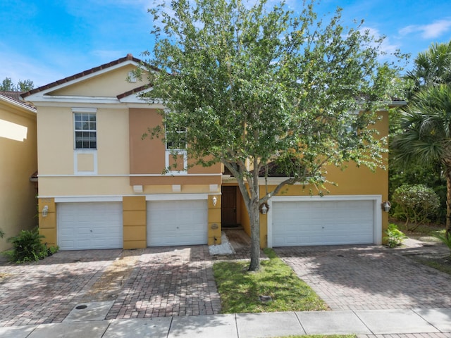 773 Pipers Cay Dr, West Palm Beach, FL 33415 - view of front of house with a garage, stucco siding, and driveway