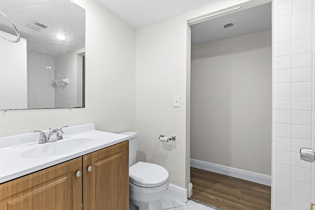 bathroom featuring vanity, a shower, and toilet