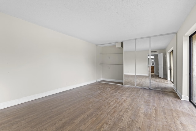 unfurnished bedroom featuring hardwood / wood-style flooring, a textured ceiling, and a closet