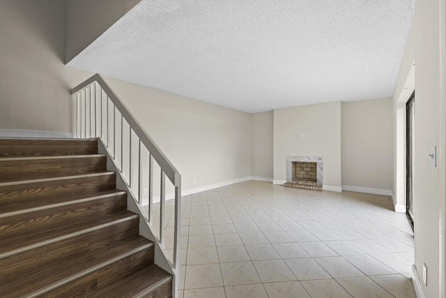 unfurnished living room with light tile patterned flooring and a textured ceiling