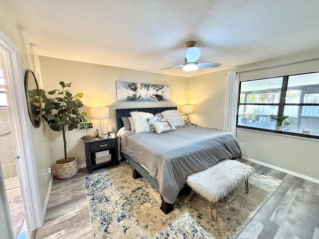 bedroom featuring ceiling fan, wood-type flooring, and a textured ceiling