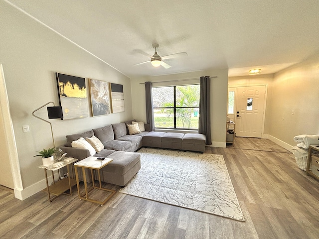 living room featuring lofted ceiling, hardwood / wood-style floors, a textured ceiling, and ceiling fan