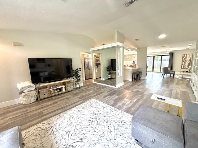 living room featuring vaulted ceiling and wood-type flooring