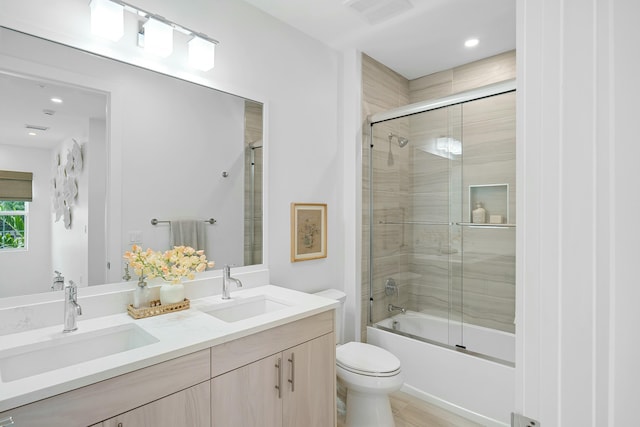 full bathroom with a sink, visible vents, toilet, and double vanity