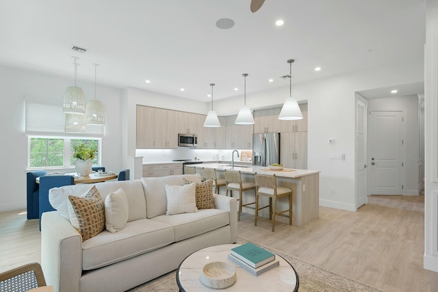 living area with recessed lighting, visible vents, baseboards, and light wood-style floors