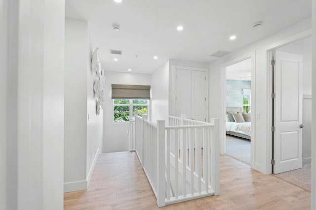 hallway with visible vents, recessed lighting, light wood-type flooring, and baseboards