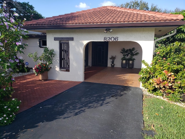 mediterranean / spanish-style house featuring a tiled roof and stucco siding