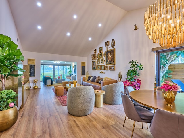 living room featuring wood-type flooring, a notable chandelier, and high vaulted ceiling