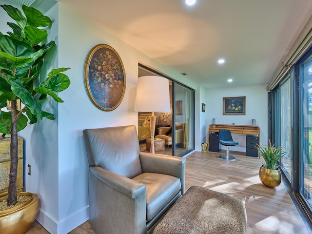 sitting room with built in desk and light wood-type flooring