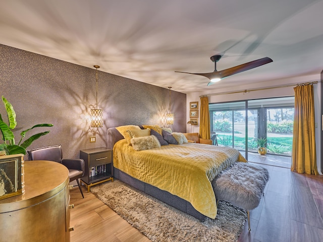 bedroom featuring wood-type flooring, access to exterior, and ceiling fan