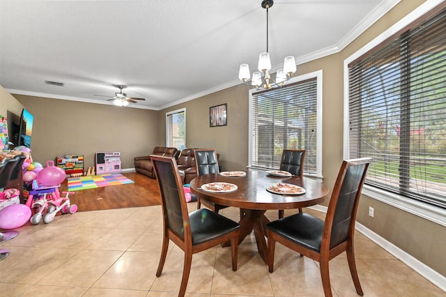 dining area featuring crown molding, ceiling fan with notable chandelier, and light tile patterned flooring