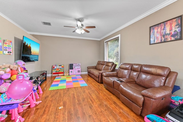 recreation room with wood-type flooring, ceiling fan, and crown molding