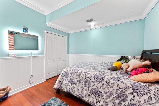 bedroom with ornamental molding, hardwood / wood-style floors, and a closet