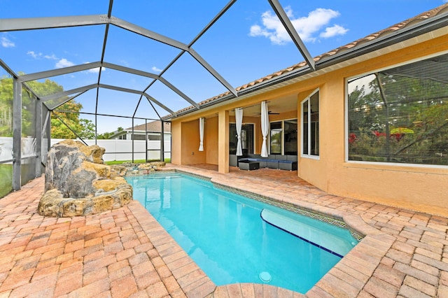 view of pool with an outdoor hangout area, a lanai, a patio area, and ceiling fan