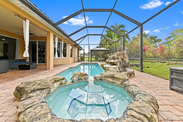 view of pool featuring ceiling fan, a patio, an outdoor hangout area, and glass enclosure