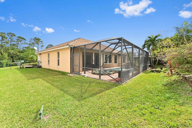 back of house featuring a lanai and a yard