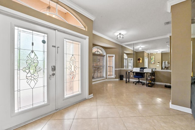 tiled foyer entrance featuring crown molding and french doors