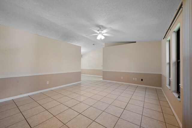 spare room with ceiling fan, a textured ceiling, and light tile patterned floors