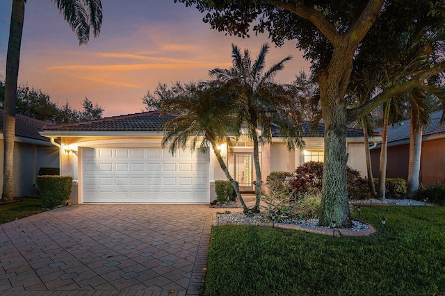 view of front of house with a garage and a lawn