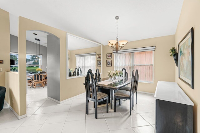 tiled dining space featuring an inviting chandelier and a healthy amount of sunlight