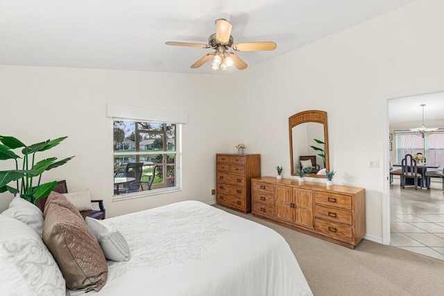 carpeted bedroom with lofted ceiling and ceiling fan with notable chandelier