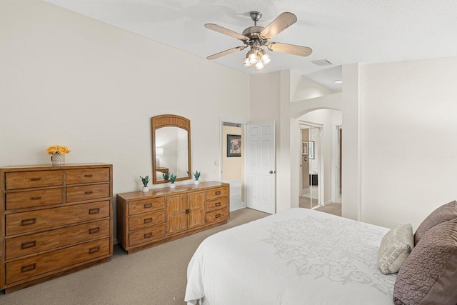 bedroom with vaulted ceiling, light colored carpet, and ceiling fan