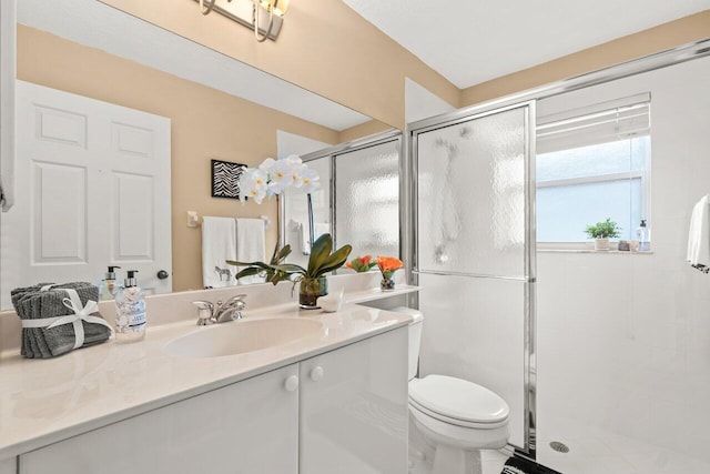 bathroom with vanity, walk in shower, and toilet