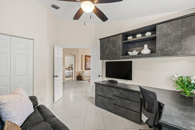 office space with lofted ceiling, light tile patterned floors, and ceiling fan