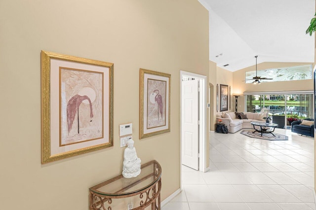 corridor with light tile patterned floors and high vaulted ceiling