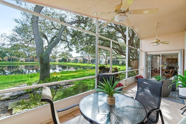 sunroom with a water view, ceiling fan, and a healthy amount of sunlight