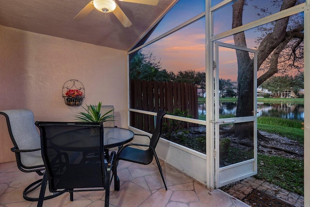 sunroom / solarium featuring a water view, ceiling fan, and lofted ceiling