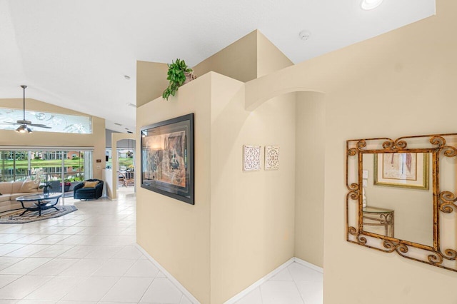 hall with lofted ceiling and light tile patterned floors