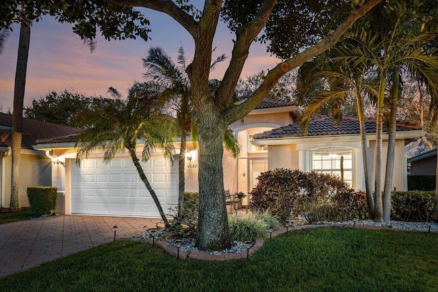 view of front of house featuring a garage and a lawn