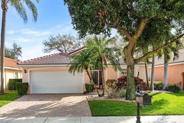 mediterranean / spanish home featuring a garage and a front lawn