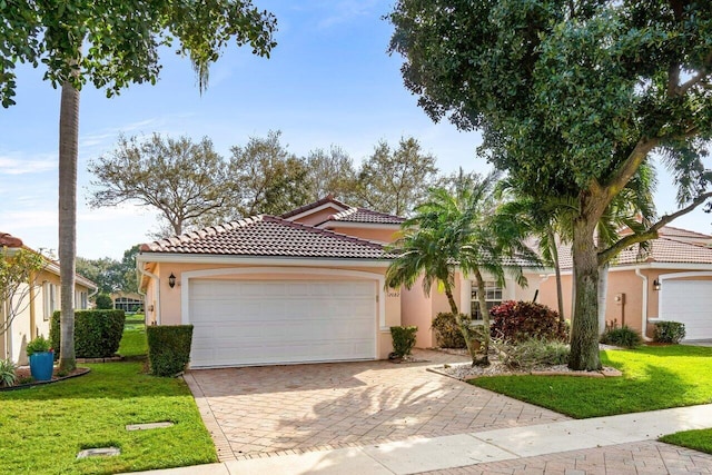 mediterranean / spanish house featuring a garage and a front lawn