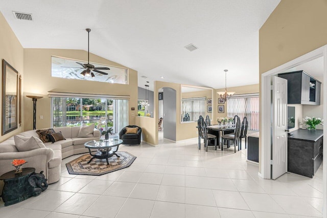 living room with light tile patterned flooring, high vaulted ceiling, ceiling fan with notable chandelier, and a textured ceiling