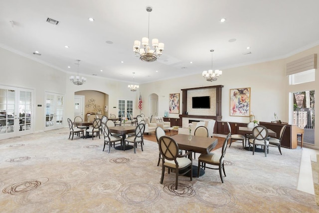 dining area with an inviting chandelier, a towering ceiling, and ornamental molding