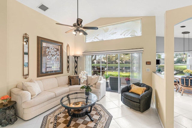 tiled living room with ceiling fan and high vaulted ceiling