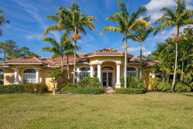 mediterranean / spanish house featuring a front yard and french doors